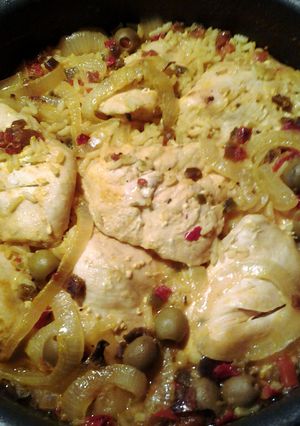 A picture of yellow rice and baked chicken.