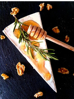 Una foto de Queso Brie con miel infusionada con naranja, vainilla y romero