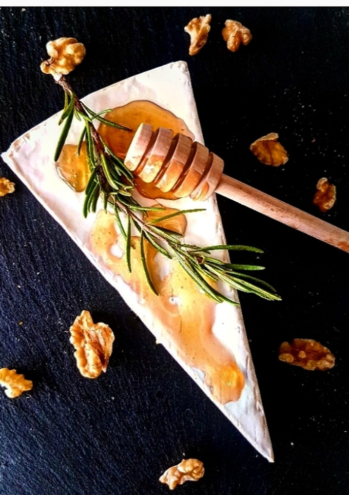 Una foto de Queso Brie con miel infusionada con naranja, vainilla y romero