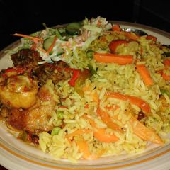 A picture of Fried Rice with pepper chicken and coleslaw.