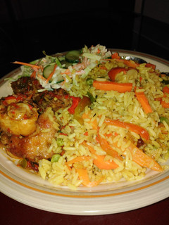 A picture of Fried Rice with pepper chicken and coleslaw.