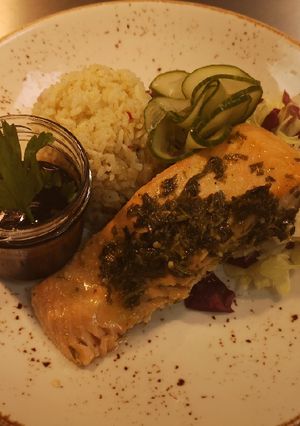 A picture of Marinated chimichurri salmon in oven served with spices rice.