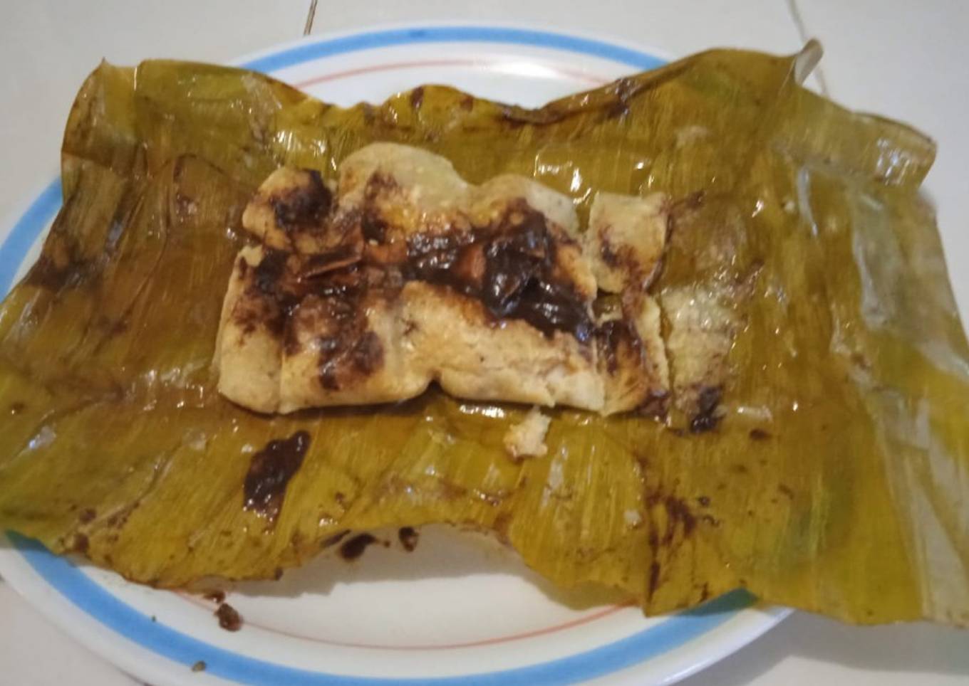 Tamal de mole negro en hoja de palma de plátano