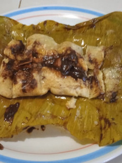 Una foto de Tamal de mole negro en hoja de palma de plátano