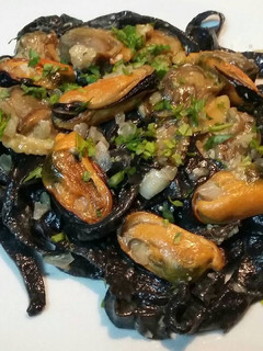 Una foto de Fetuccini nero con salsa de mariscos