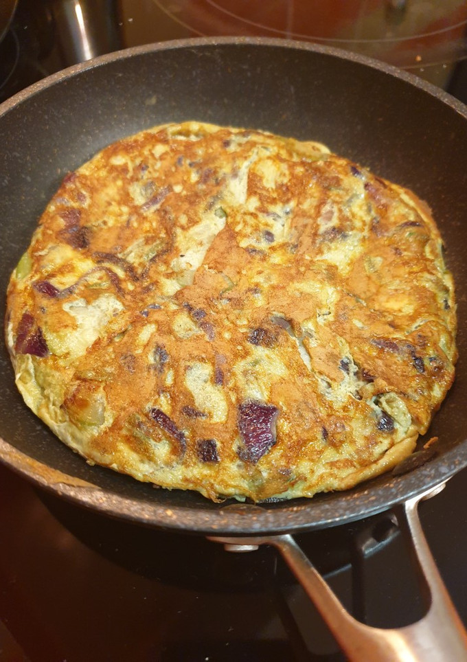 Una foto de Tortilla de calabacín y cebolla morada, jugosa y ligera