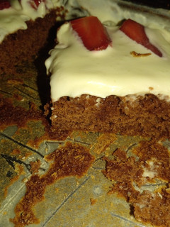 Una foto de Brownies húmedos con crema y frutillas