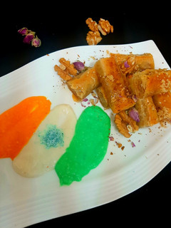 A picture of Walnuts baklawa served with cream.