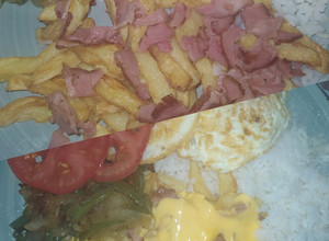 Una foto de Papas fritas con panceta y salsa cheddar 😋👌