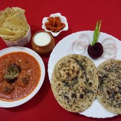 A picture of Vegetable kofta in red gravy with mint naan.