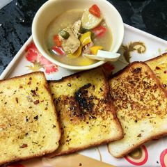 A picture of Chicken stew with garlic bread.
