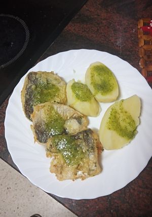 Una foto de Bocados de merluza adobada y frita con papas y mojo verde