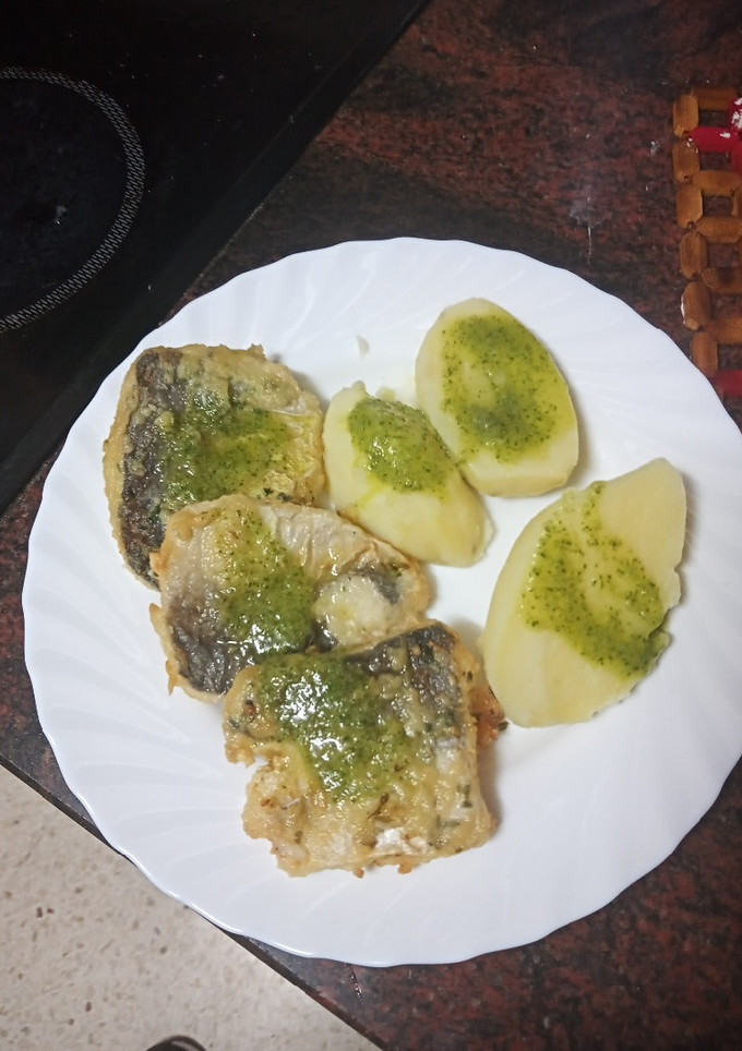 Una foto de Bocados de merluza adobada y frita con papas y mojo verde