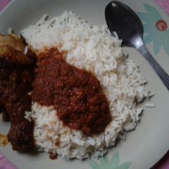 A picture of Chicken stew on white rice.