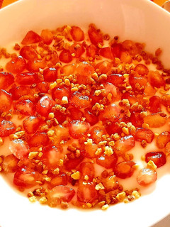 Una foto de Yogur con toppings de granada y almendra crocante