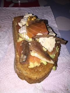 Una foto de Tostada de aguacate, anchoas y queso