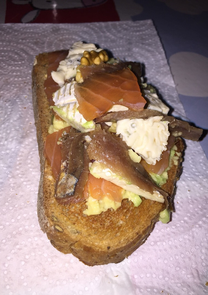 Una foto de Tostada de aguacate, anchoas y queso