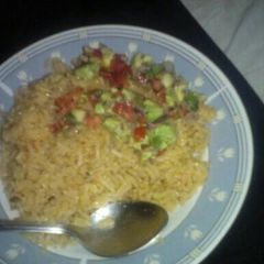 A picture of Rice with avocado and tomato salad.