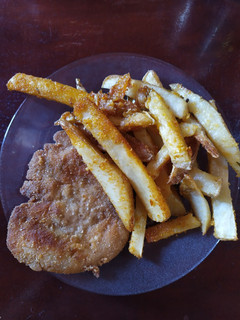 Una foto de Milanesas fritas acompañadas de papas rústicas al horno