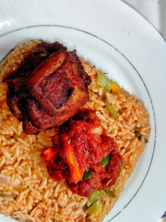 A picture of Ghanaian vegetable Jollof rice with red seasoned chicken.
