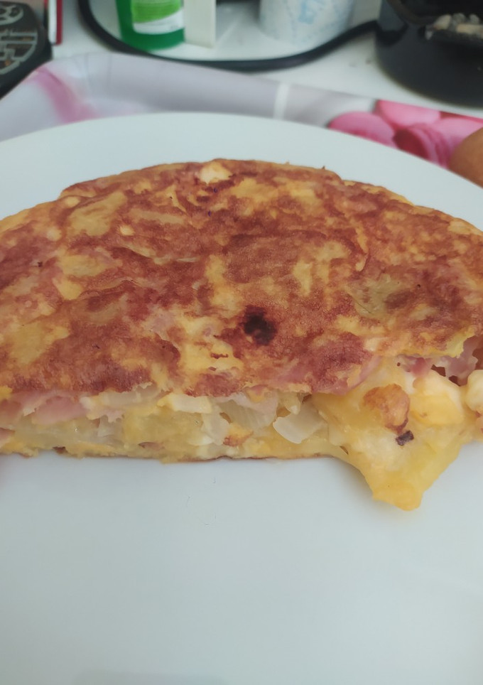 Una foto de Tortilla de patatas rellena de jamón york y quesitos deliciosa