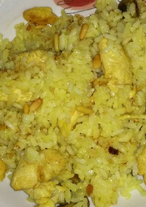 Una foto de Arroz con pinchitos amarillos de pollo con champiñones y piñones