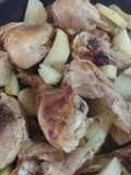 Patitas de pollo doradas en sartén, con cebollas, especias y papas