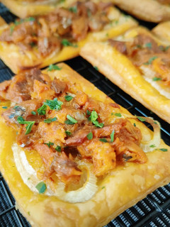 Una foto de Tostadas de hojaldre con cebolla, atún y arenque en salsa de tomate