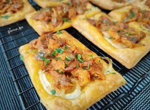 Una foto de Tostadas de hojaldre con cebolla, atún y arenque en salsa de tomate