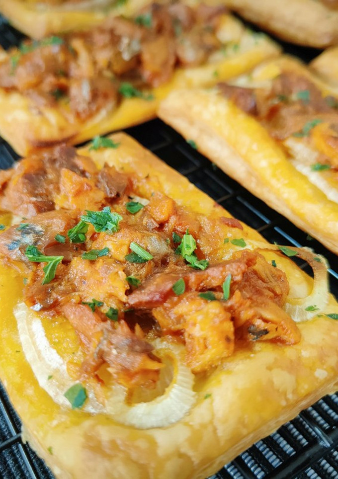 Una foto de Tostadas de hojaldre con cebolla, atún y arenque en salsa de tomate