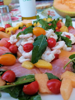 Foto di Carpaccio di salmone e gamberetti su letto di rucola ciliegini e frutta