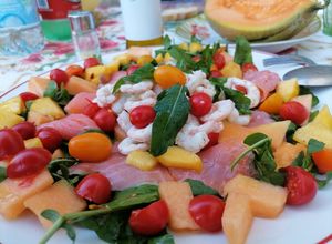 Foto di Carpaccio di salmone e gamberetti su letto di rucola ciliegini e frutta