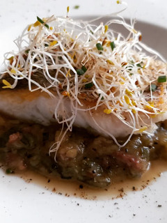 Una foto de Merluza a la plancha con salsa de calabacín y jamón al tomillo