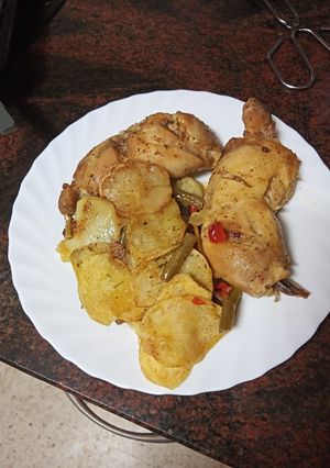 Foto principal de Muslitos de pollo sobre cama de papas y verduras al horno
