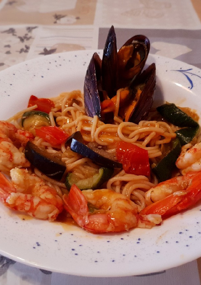 Una foto de Espaguetis🍝 con verduras, gambones y mejillones en salsa picante