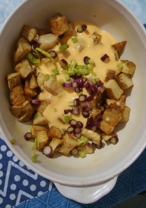Una foto de Papas con cheddar y cebolla de verdeo