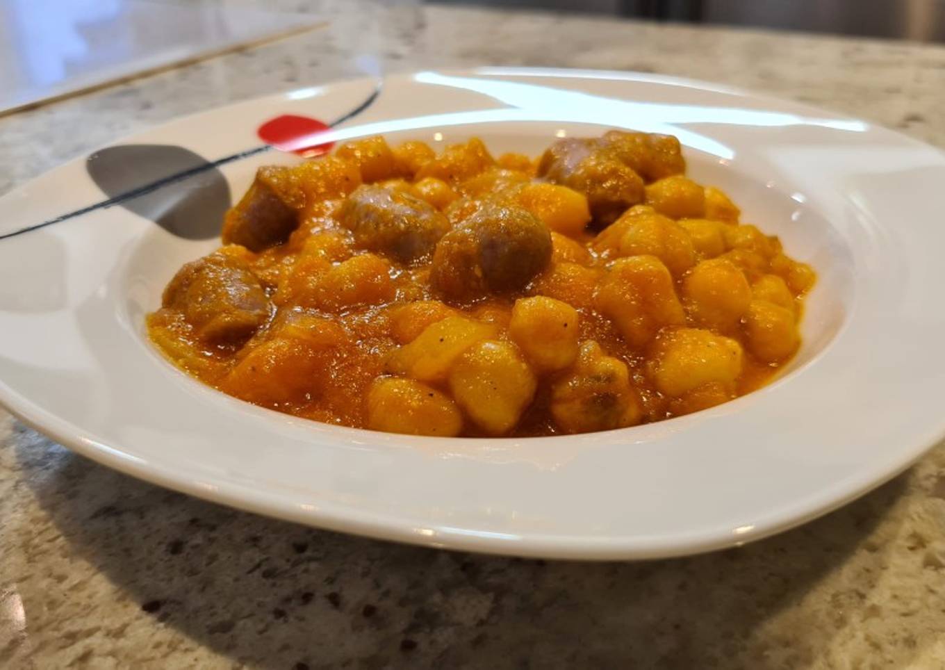 Garbanzos en salsa de piquillos y tomate con salchichas frescas