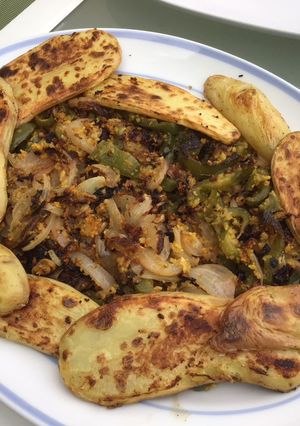 Une photo de Pommes de terre grillées aux poivrons et oignons roses croustillants épicés