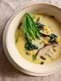 Zuppa di latte di cocco, mais, funghi e spinaci