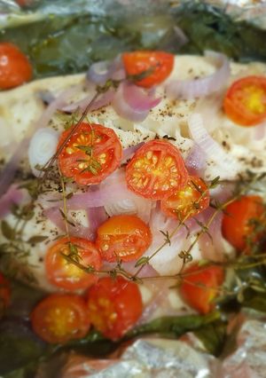 Una foto de Pescado empapelado con espinaca y jitomate uva