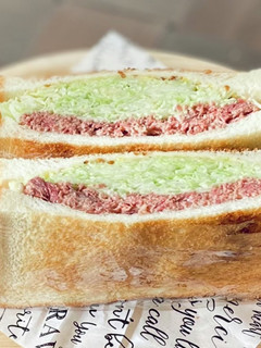A picture of Corned Beef Sandwich with Lots of Cabbage.