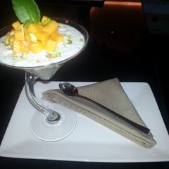 A picture of rice pudding with mango and basil.