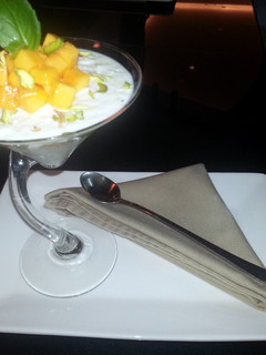 A picture of rice pudding with mango and basil.