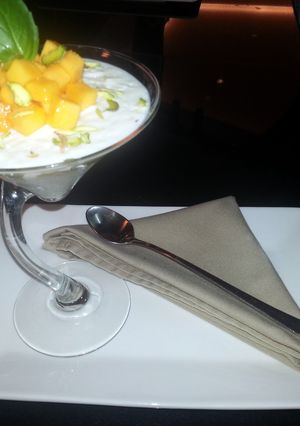 A picture of rice pudding with mango and basil.