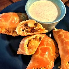 A picture of Wagyu Chorizo Empanadas with Roasted Poblano Crema.