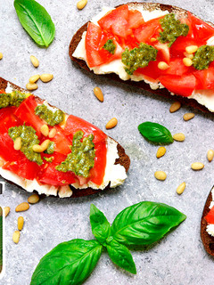 Una foto de Tostada de pan de centeno con tomate, queso fresco, piñones y salsa pesto
