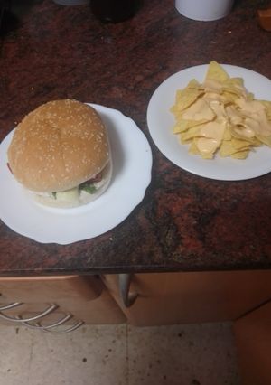 Una foto de Hamburguesa de cerdo con mayonesa de cebolla frita y piparras