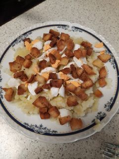 Una foto de Puré de patata con huevo duro y taquitos de pan duro frito