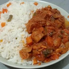 A picture of Beef and mushroom stew paired with garnished coconut rice.