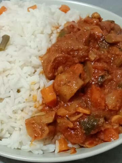 A picture of Beef and mushroom stew paired with garnished coconut rice.
